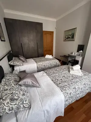 three beds in a room with a desk at ALGA Roma in Rome
