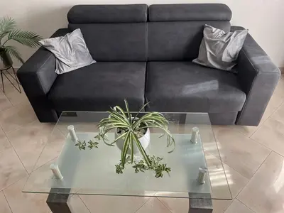 a living room with a black couch and a glass table at ALGA Roma in Rome