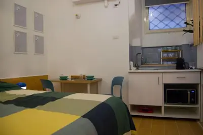 a bedroom with a bed and a table and a kitchen at Breathe Romance San Giovanni in Rome