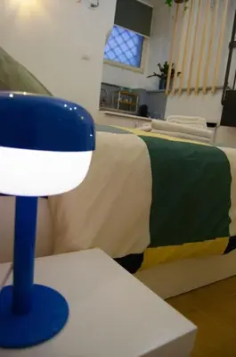 a blue and white lamp on a table next to a bed at Breathe Romance San Giovanni in Rome
