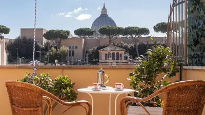 a table and chairs on a balcony with a view of a city at Rental in Rome Sistina View in Rome