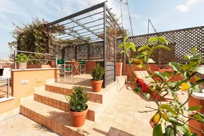 a rooftop patio with potted plants and a pergola at Central Station Enchanting Apartments in Rome