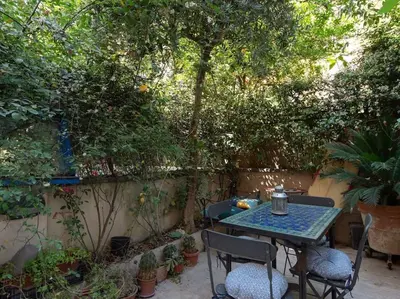 a table and chairs in a garden with trees at Central Station Enchanting Apartments in Rome