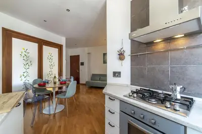 a kitchen with a stove and a table with chairs at HospitalityRome Nice Apartment in Rome