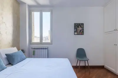 a bedroom with a white bed and a blue chair at HospitalityRome Nice Apartment in Rome