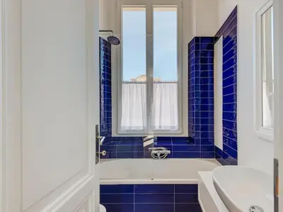 a blue tiled bathroom with a tub and a sink at Vatican Luxury Apartment in Rome
