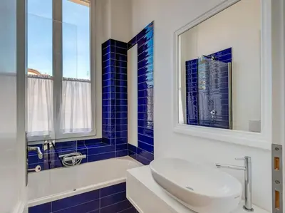 a blue tiled bathroom with a sink and a tub at Vatican Luxury Apartment in Rome