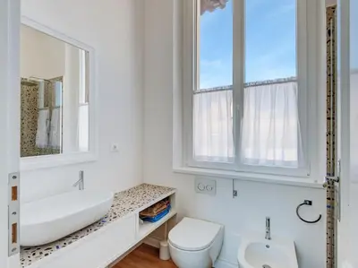 a bathroom with a sink and a toilet and a mirror at Vatican Luxury Apartment in Rome