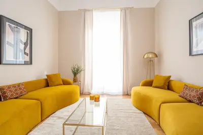 a living room with a yellow couch and a table at Daplace - Allegra Apartment in Rome