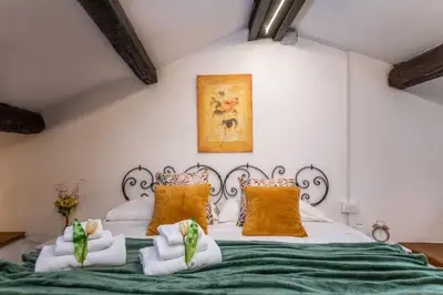 a bedroom with a large bed with green sheets at RomAntica Bocca della Verità in Rome