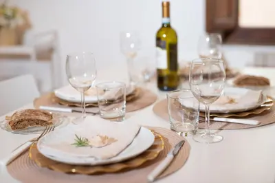 a table with plates and glasses and a bottle of wine at RomAntica Bocca della Verità in Rome