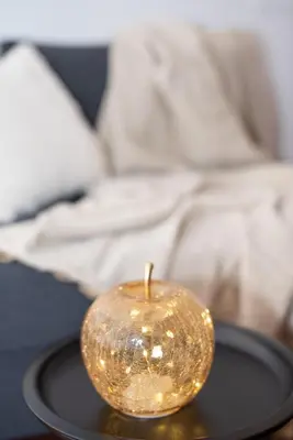 a gold apple sitting on a black plate on a table at RomAntica Bocca della Verità in Rome
