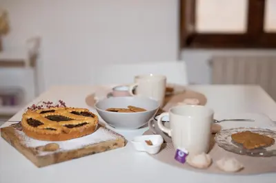 a table with two cups and a cake and cookies at RomAntica Bocca della Verità in Rome