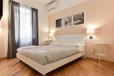 a white bedroom with a bed and a window at Nerhome Vatican Suite in Rome