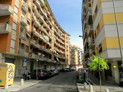 a city street with parked cars and tall buildings at Nerhome Vatican Suite in Rome