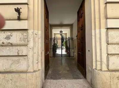 a hallway with two entrances to a building with wooden doors at Casa Gigi al Vaticano in Rome