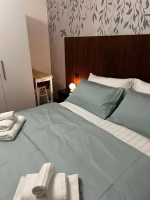 a bed with green sheets and towels on it at Vatican Design Suites in Rome