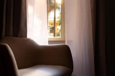 a chair sitting in front of a window at Vatican Design Suites in Rome