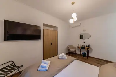 a bedroom with a bed and a tv on the wall at Vatican Design Suites in Rome