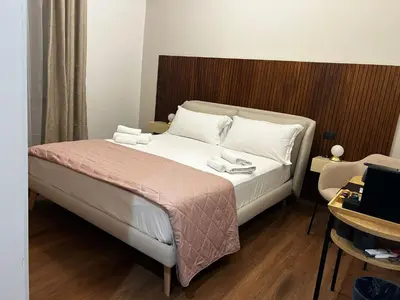 a bedroom with a bed with white sheets and pillows at Vatican Design Suites in Rome