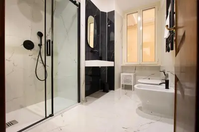 a bathroom with a shower and a toilet and a sink at Vatican Design Suites in Rome