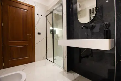 a bathroom with a sink and a glass shower at Vatican Design Suites in Rome