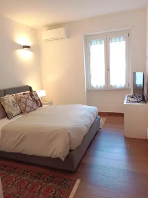 a bedroom with a large bed and two windows at Soraya Home in Rome