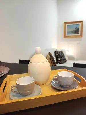 two cups and a vase sitting on a wooden tray at Soraya Home in Rome