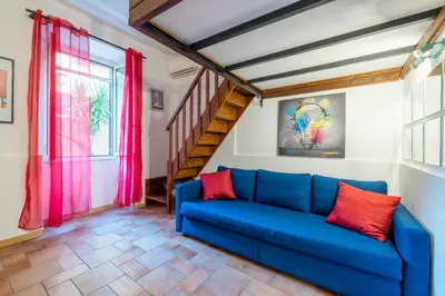 a living room with a blue couch and a staircase at CASA GIOVI - Apartment with garden in Rome