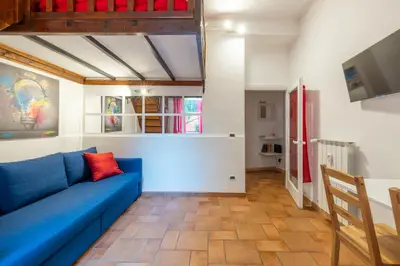 a living room with a blue couch and a tv at CASA GIOVI - Apartment with garden in Rome