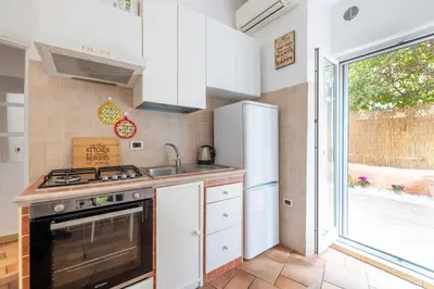 a kitchen with a stove and a sink and a window at CASA GIOVI - Apartment with garden in Rome