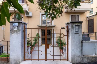 a gate in front of a building with potted plants at CASA GIOVI - Apartment with garden in Rome