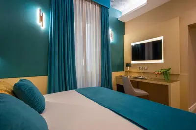 a bedroom with a bed and a desk and a television at VentiSettembre Private Suites in Rome