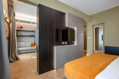 a bedroom with a bed and a tv on a wall at VentiSettembre Private Suites in Rome