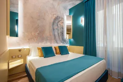 a bedroom with a bed and a painting on the wall at VentiSettembre Private Suites in Rome