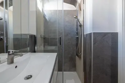 a bathroom with a shower and a white sink at Quattro Fontane 4P - B&D Apts in Rome