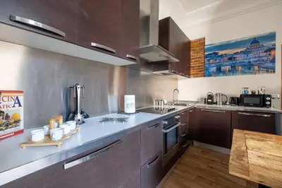 a kitchen with stainless steel appliances and a wooden table at Quattro Fontane 4P - B&D Apts in Rome