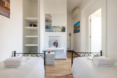 two beds in a room with white walls at Quattro Fontane 4P - B&D Apts in Rome