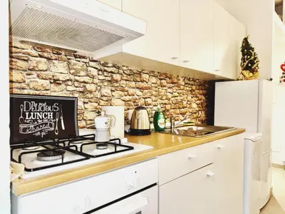 a kitchen with a stove and a stone wall at Scala Santa Home in Rome