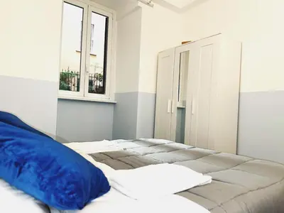 a bedroom with a bed with a blue pillow on it at Scala Santa Home in Rome