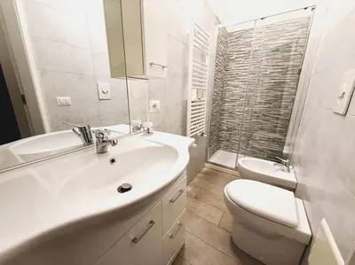 a white bathroom with a sink and a toilet at Scala Santa Home in Rome
