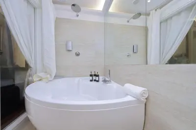 a white bath tub in a bathroom with a shower at Vicolo Savelli Luxury Suites in Rome