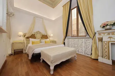 a bedroom with a king sized bed and a window at Vicolo Savelli Luxury Suites in Rome