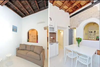 a kitchen and a living room with a couch and a table at Campo de fiori charm apartment in Rome