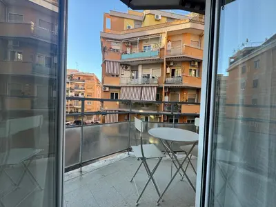 a balcony with a table and a view of a building at Urban Oasis Near Appia Antica Park in Rome