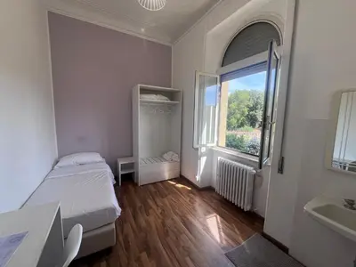 a small bedroom with a bed and a window at Green Park San Pancrazio in Rome