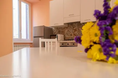 a kitchen with a white counter top and purple flowers at Sophie's choice 3 e Sophie's choice 4 in Rome