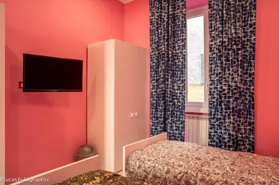 a bedroom with pink walls and a bed and a tv at Sophie's choice 3 e Sophie's choice 4 in Rome