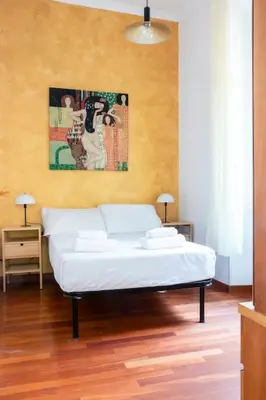 a bedroom with a white bed and a painting on the wall at colosseo view apartment in Rome