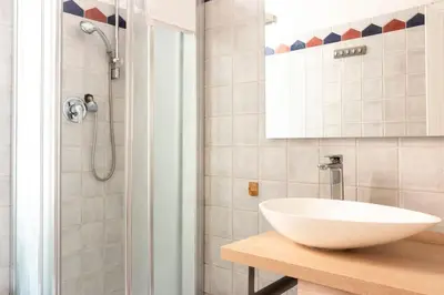 a bathroom with a white sink and a shower at colosseo view apartment in Rome